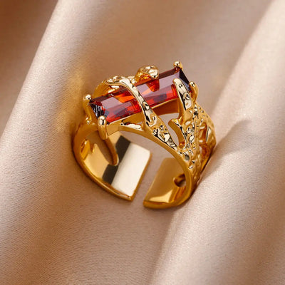 Anillo de acero inoxidable de lujo en tono dorado con piedra preciosa simulada.