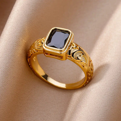 Anillo de acero inoxidable de lujo en tono dorado con piedra preciosa simulada.
