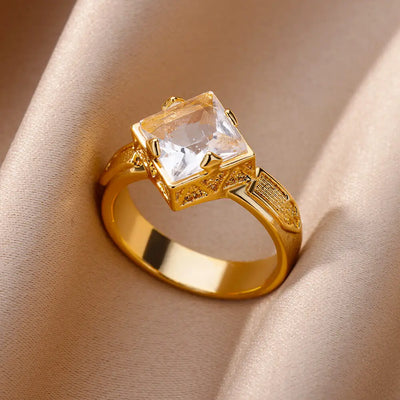Anillo de acero inoxidable de lujo en tono dorado con piedra preciosa simulada.
